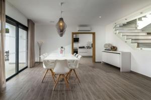 een eetkamer met een witte tafel en witte stoelen bij Elegant Luxury Villa by Ideal Homes in Almancil