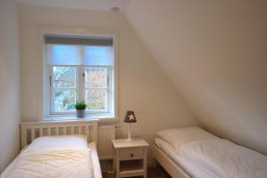 2 Betten in einem Zimmer mit Fenster in der Unterkunft Haus Boldix Whg 1 Aruba in Boldixum