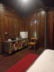 Cette chambre dispose d'une cuisine avec des murs en bois et un tapis rouge. dans l'établissement Gladak Mesari, à Keramas