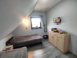 a small bedroom with a bed and a window at Mazury Dom Oskar nad jeziorem Sasek Wielki in Szczytno