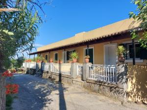 a house with potted plants on a fence at Kidonakia Apartments in Agios Ioannis