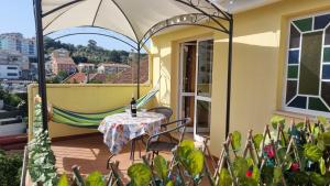 a patio with a table and a hammock on a balcony at Casa Anjos in Coimbra