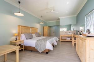 a bedroom with a large bed and a bathroom at Little Pilgrims Boutique Hotel in Hazyview