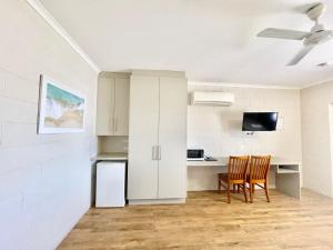 a kitchen and dining room with a table and chairs at Yongala Lodge by The Strand in Townsville