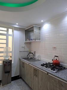 a kitchen with a sink and a stove top oven at Lux suites Utawala Family House in Nairobi