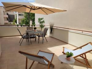 a patio with a table and chairs and an umbrella at Irida Apartment Nafplio in Nafplio