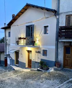 biały dom z balkonem na ulicy w obiekcie Piccola dimora accogliente e molto panoramica w mieście Tagliacozzo