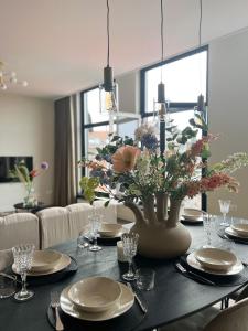 een eettafel met een vaas met bloemen erop bij Reen Luxury Stays - Waterpoort -2 bedrooms, 4 pers in Sneek