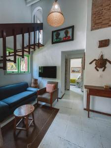 a living room with a blue couch and a table at Vila dos Tangarás, Casa 1 Praia, a 30m do mar in Toque Toque Grande