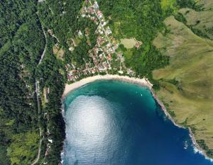 une vue aérienne sur un lac avec un groupe de maisons dans l'établissement Vila dos Tangarás, Casa 1 Praia, a 30m do mar, à Toque Toque Grande