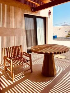 a wooden table and a bench and a table and chair at Villa Lavayarena in La Oliva