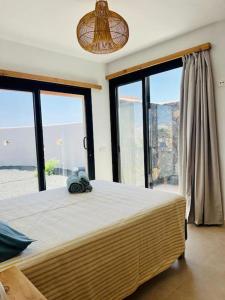 1 dormitorio con 1 cama grande y ventanas grandes en Villa Lavayarena, en La Oliva