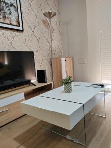 uma sala de estar com uma mesa de café branca e uma televisão em Urbanlux Recinto Ferial em Albacete