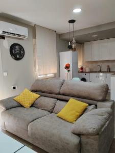 um sofá com almofadas amarelas na cozinha em Urbanlux Recinto Ferial em Albacete