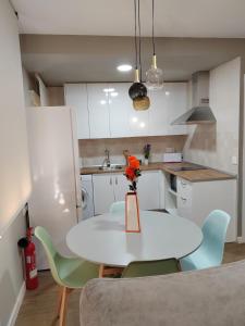 a white kitchen with a white table and chairs at Urbanlux Recinto Ferial in Albacete