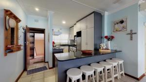 a kitchen with a bar with stools around it at Breathtaking views from Sue Casa 11 in Margate
