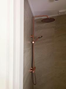 een douche met een metalen handvat in een badkamer bij Reen Luxury Stays - Waterpoort -2 bedrooms, 4 pers in Sneek