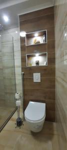 a bathroom with a toilet with wooden walls at Apartman B&D in Tuzla +17 photos