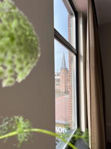 a window with a view of a church at Reen Luxury Stays - Waterpoort -2 bedrooms, 4 pers in Sneek