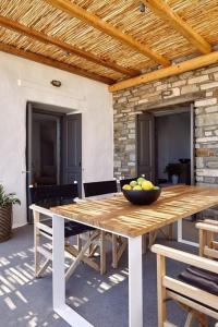 - une table en bois avec un bol de fruits dans l'établissement Platinum Paros Villa - Villa Azure - 5 Bedrooms - Sea Views & Private Pool - Naoussa, à Kolympithres