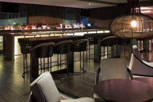 a bar with chairs and tables in a restaurant at Sheraton Hyderabad Hotel in Hyderabad