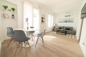 バルセロナにあるアパートメンツ ガウディ バルセロナの白いリビングルーム(テーブル、椅子付)