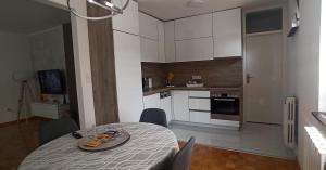 a kitchen with a table with chairs and a dining room at Apartman B&D in Tuzla