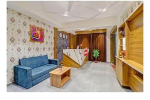 a living room with a blue couch and a table at hotel stay inn in Ahmedabad