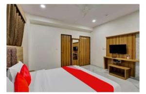 een slaapkamer met een bed en een televisie. bij hotel stay inn in Ahmedabad