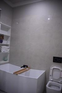 a bathroom with a white tub and a toilet at Cozy BoxHill - Modern Stylish Share House in Box Hill