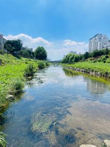 einen Fluss in einer Stadt mit Gebäuden im Hintergrund in der Unterkunft ARMYCasa with 2 rooms and 1 bathroom in Seoul