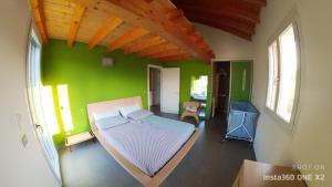 1 dormitorio con 1 cama en una pared verde en "Lake & Mountain" Summer House, en Colico