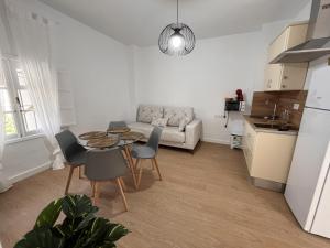 a kitchen and a living room with a table and chairs at apartamentos Larios centro in Sanlúcar de Barrameda