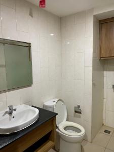 a bathroom with a white toilet and a sink at Lavenderbnb Room 6 at Mataram City in Yogyakarta +4 photos