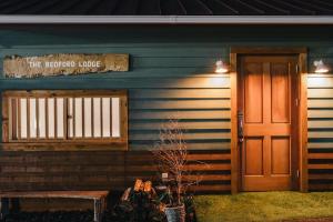 una casa con una puerta y un letrero que lee el lodge de la termopofer en THE BEDFORD LODGE, en Izumisano