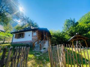 une petite maison en bois avec une clôture à côté dans l'établissement BATS CAVE HUT - Transylvania - Hot-Tub - Sauna, à Sub Piatra