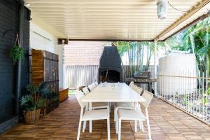 VIVID - House w heated pool, ev station, fireplace في Summerland Point: طاولة وكراسي على فناء مع موقد