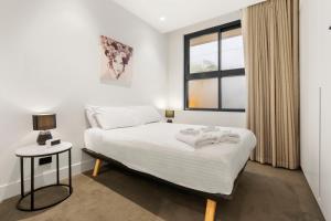 - une chambre blanche avec un lit et une fenêtre dans l'établissement THE SHORE: COOGEE BEACH, à Sydney