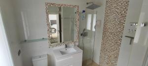 a bathroom with a toilet and a sink and a mirror at Beach House El Saladillo in Estepona +16 photos