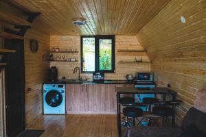 a kitchen in a log cabin with a washing machine at Lonely Mountain in Kazbegi
