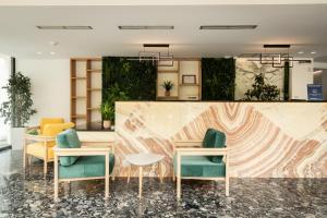 a lobby with two tables and two chairs and a counter at Dorchester Hotel in Sarandë