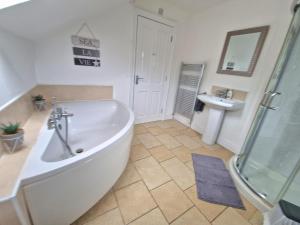 ein Badezimmer mit einer großen Badewanne und einem Waschbecken in der Unterkunft GlenVista Holiday Accommodation in Glenariff