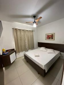 a bedroom with a bed and a ceiling fan at Hotel Rota Do Sol in Patrocínio
