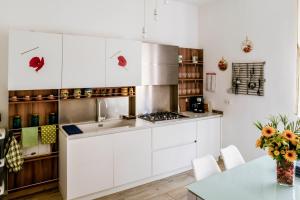 une cuisine avec des placards blancs et une table dans l'établissement Vale a Livorno, à Livourne