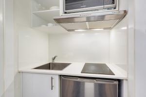 a kitchen with a sink and a microwave at Modern and Cosy Sydney CBD Studio in Central in Sydney