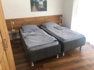 two twin beds in a room with wooden floors at Gästehaus Jagsttal in Möckmühl