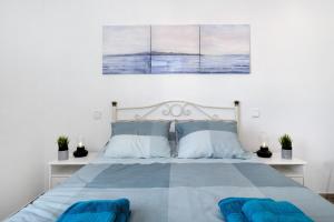a bedroom with a bed with two blue pillows at Viviendas El Pescador - Ancla in El Golfo