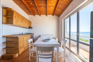 cocina con mesa y sillas y vistas al océano en Villa Cesira, en SantʼAndrea