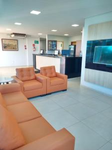 a waiting room with two orange chairs and a counter at Hotel Rota Do Sol in Patrocínio
