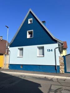 un edificio azul y blanco al lado de una calle en Ferienwohnung Blaues Haus en Ubstadt-Weiher
